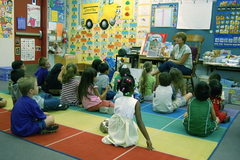 A teacher reads a story to kindergarteners (click for credit)